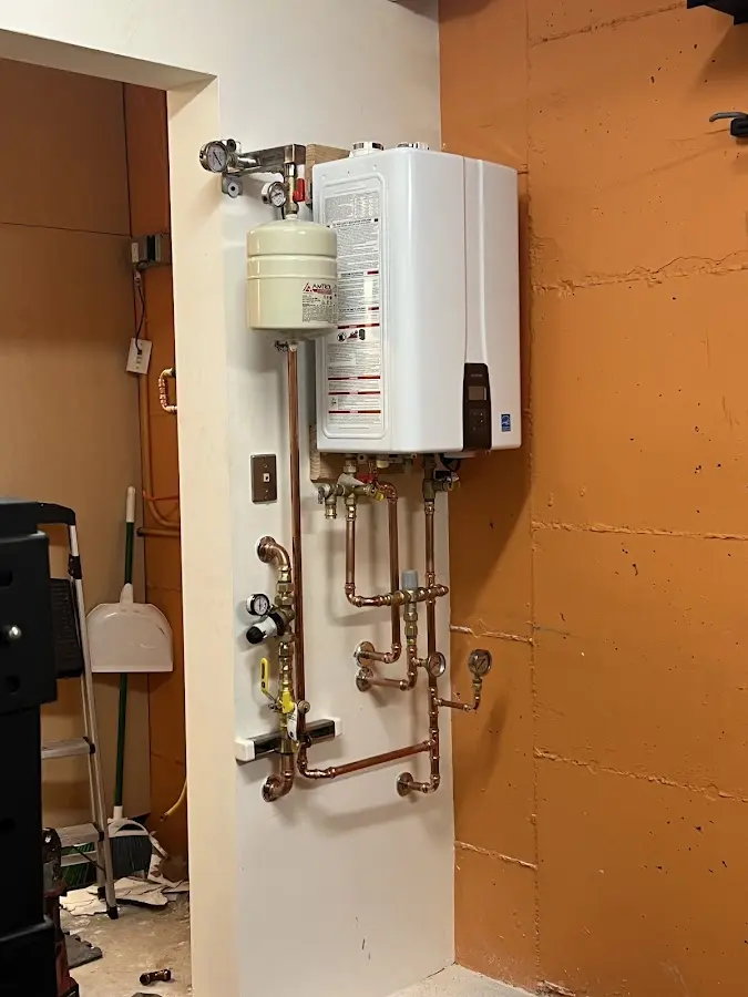 Plumbing technician inspecting water heater connections in Whitestown